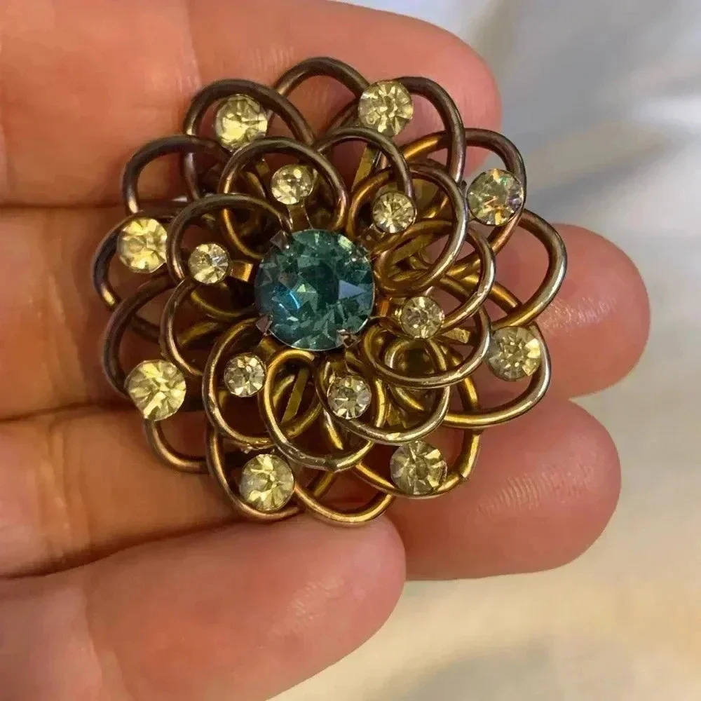 Vintage goldtone pin/ brooch w/ blue center rhinestone surrounded by rhinestones